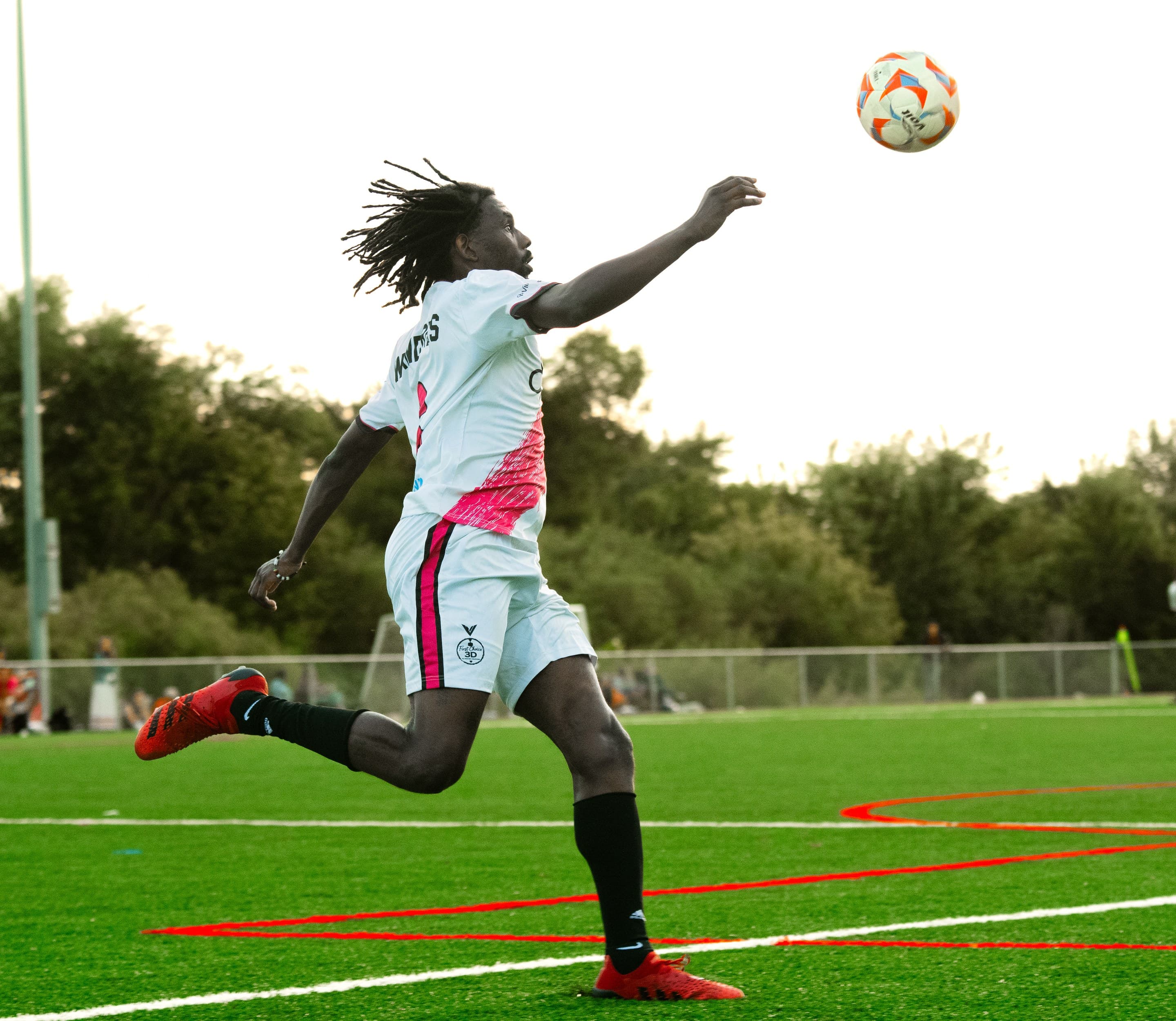 A Wanderers player volleys the ball