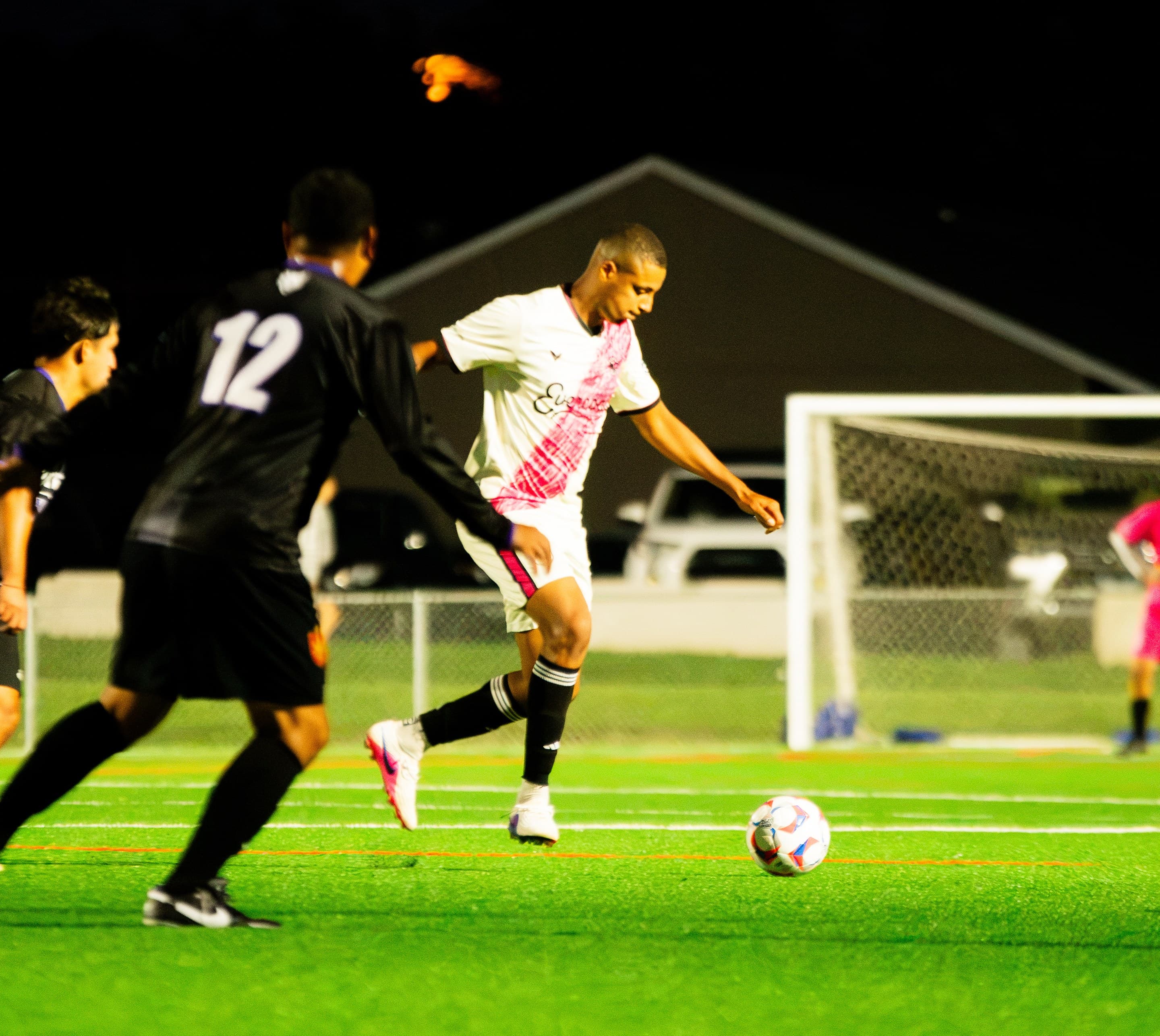 A Wanderers player on the ball under the lights